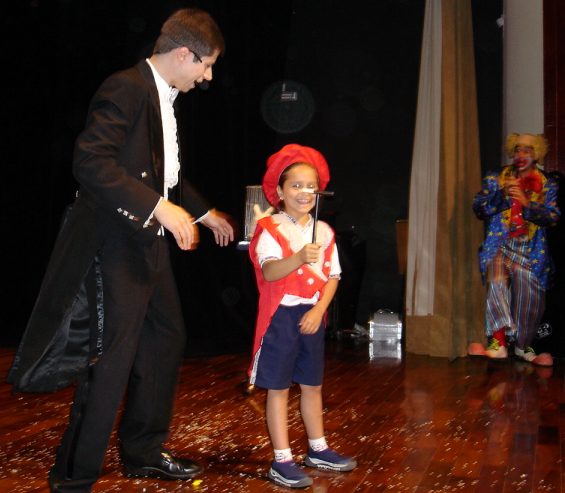 M�gico Fabian Rodrigues com uma aluna e o apresentador Palha�o Biriba